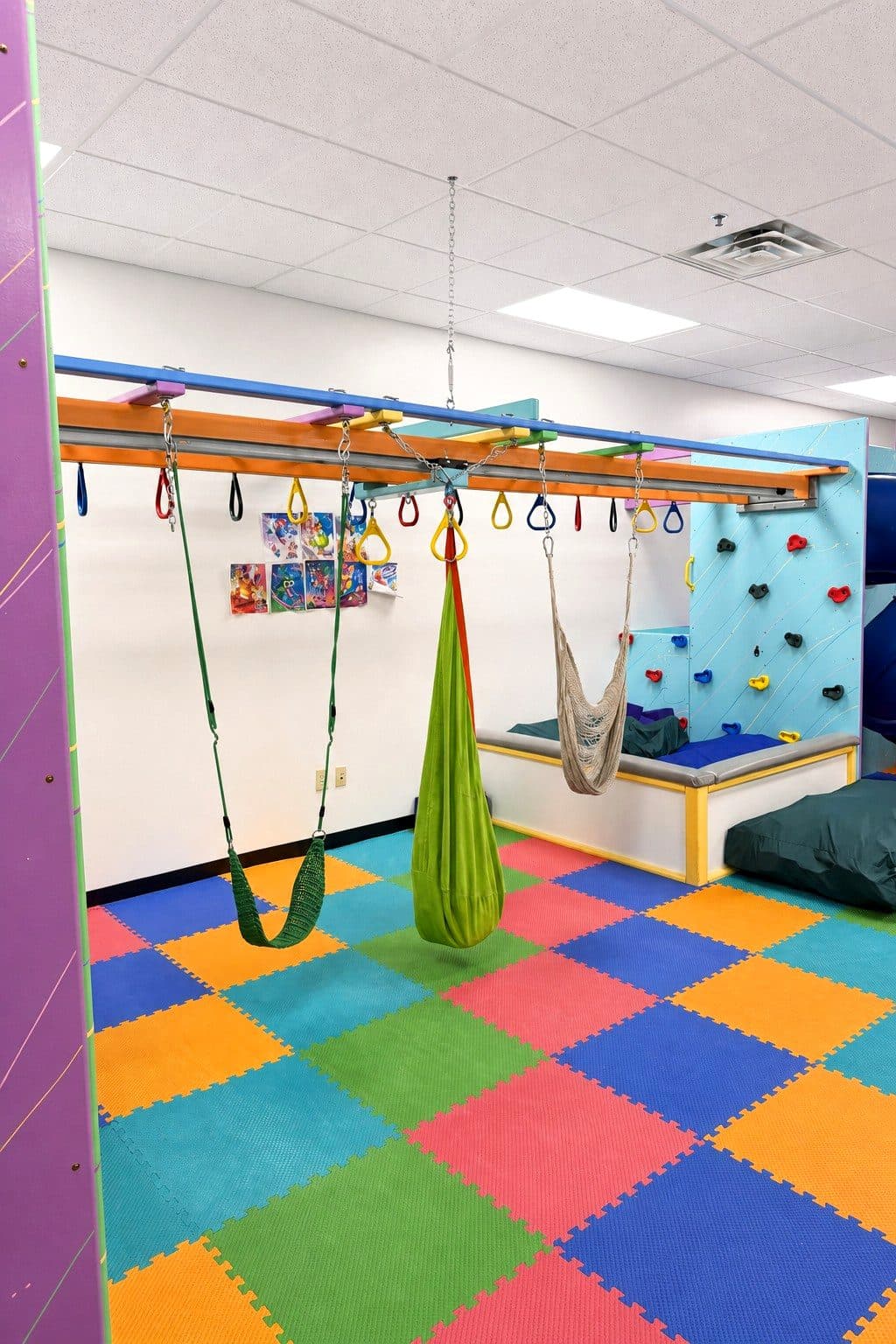 Swings and a climbing wall in the sensory gym at our Eagan clinic